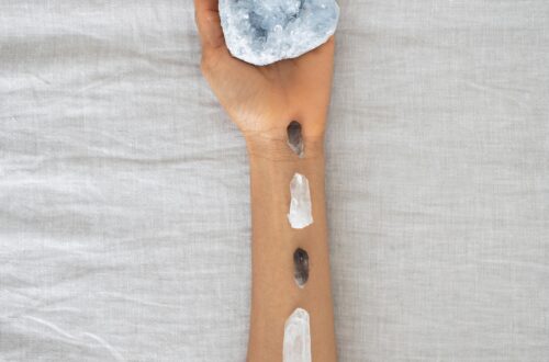 A serene arrangement of crystals on an arm over a soft linen backdrop, emphasizing holistic healing.